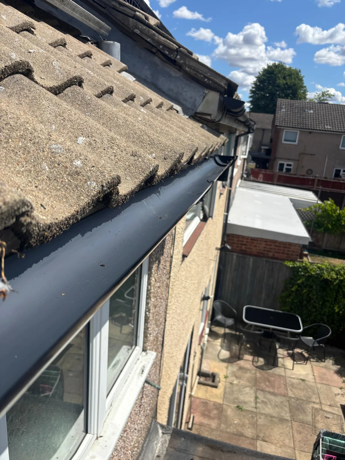 Repaired gutter running along a tiled roof edge